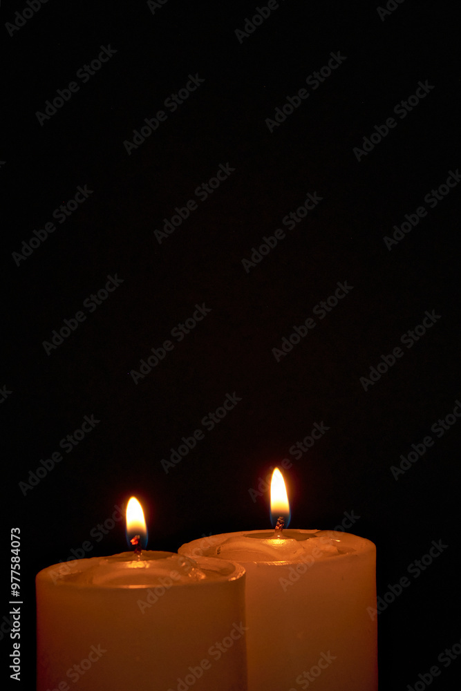 Candles burning against a black background illuminate a hope of faith Candles burning against a black background illuminate a hope of faith