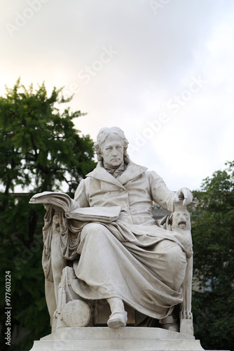 Statue of Wilhelm von Humboldt at Humboldt University in Berlin, Germany, celebrating his legacy in education and philosophy amid green surroundings