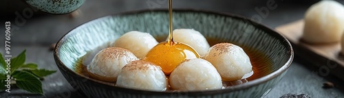 Chef drizzling syrup over a bowl of warabi mochi, soft and translucent with kinako powder, warabi mochi, Japanese dessert, light and delicate photo