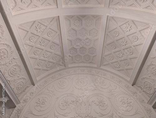detail of the ceiling of a interior museum space with floral carvings in white