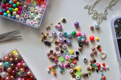 Obraz na płótnie Colorful beads, letter beads, threads and other jewelry making supplies on white background. Making friendship bracelets concept. Flat lay. w salonie