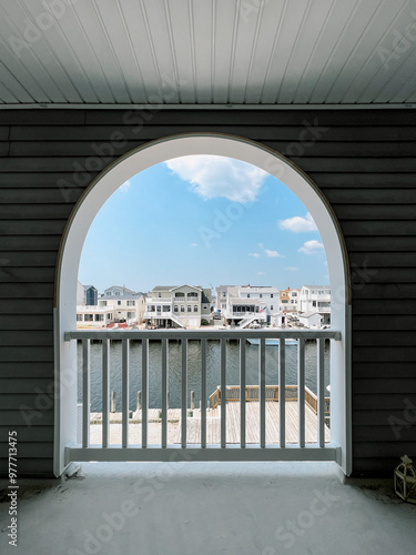 Arched window looking out at the bay from the outside deck of a home in Long Beach Island photo