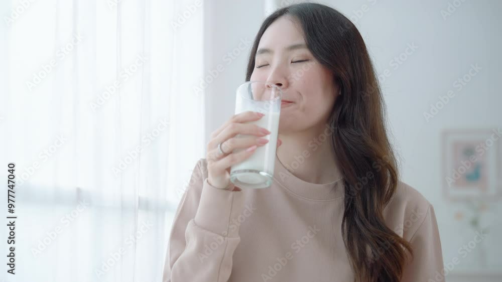 Asian woman drinking milk from glass, health care concept
Asian woman drinking milk from glass, health care concept