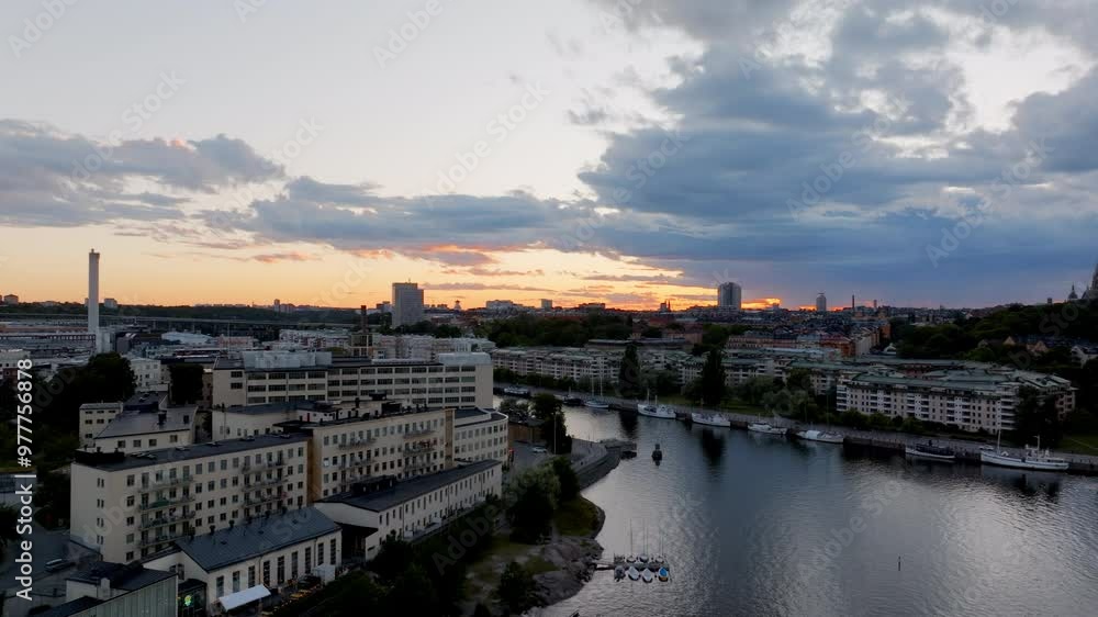 Warm sunset light bathes Stockholm's buildings and waterways. Boats glide smoothly through the water as clouds drift across the vibrant, colorful sky Warm sunset light bathes Stockholm's buildings and waterways. Boats glide smoothly through the water as clouds drift across the vibrant, colorful sky