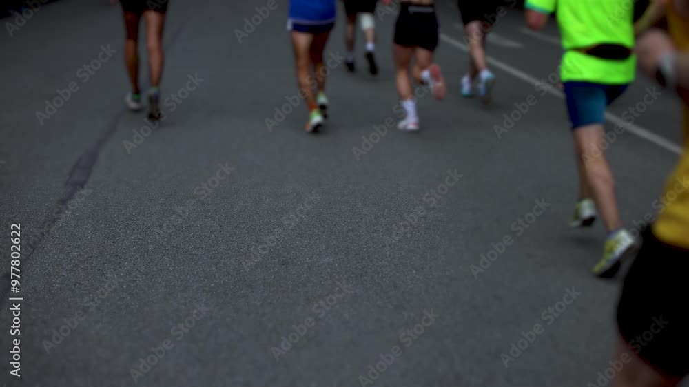 Marathon runners crowd, sportsmen participants start running the half-marathon in the city streets, crowd of sportswomen joggers in motion, group athletes outdoor training competition in a summer day Marathon runners crowd, sportsmen participants start running the half-marathon in the city streets, crowd of sportswomen joggers in motion, group athletes outdoor training competition in a summer day