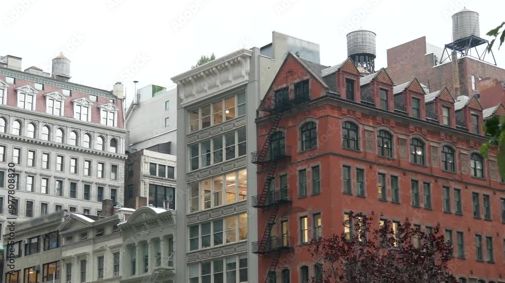 New York City 5 Fifth avenue, Manhattan midtown building corner architecture. Urban residential house exterior. Real estate property in USA. Typical red brick facade. Rooftop water tower, tank on roof New York City 5 Fifth avenue, Manhattan midtown building corner architecture. Urban residential house exterior. Real estate property in USA. Typical red brick facade. Rooftop water tower, tank on roof