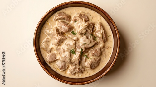 A plate of blanquette de veau, a creamy veal stew, isolated on a light beige background to highlight the velvety sauce and tender meat