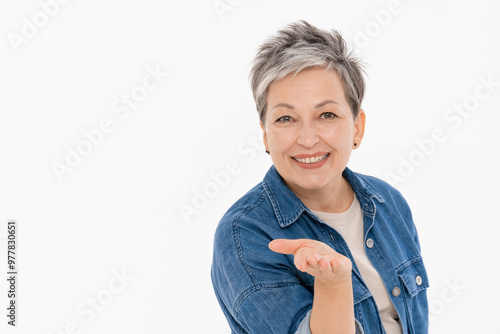 Принти на полотні Smiling middle-age woman lady with short grey hair in casual outfit white t-shirt denim send blowing a kiss with hand point hand camera on you isolated copy space