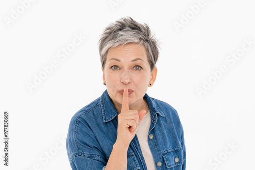 Картината върху платно Smiling mature 50s age woman holding finger on lips mouth keep it quiet secret information