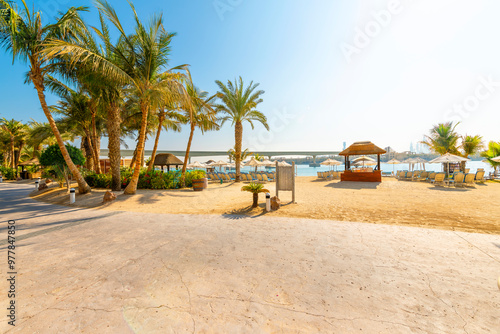 Canvas Print Lounge chairs, palm trees and huts along a sandy beach and resort on Palm Jumeirah island, on the Arabian Gulf at Dubai, United Arab Emirates