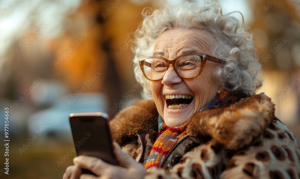 Funny old woman looking at a smartphone screen and laughing. Funny old woman looking at a smartphone screen and laughing.