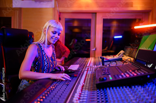 Bild auf Leinwand Woman music producer and engineer working at the soundboard in a music studio