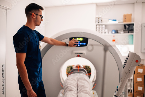 Technologist preparing the CT scanner for a patient examination photo