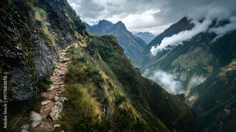 A narrow mountain path along a steep cliff with panoramic views of the surrounding valleys and peaks under a cloudy sky. A narrow mountain path along a steep cliff with panoramic views of the surrounding valleys and peaks under a cloudy sky.
