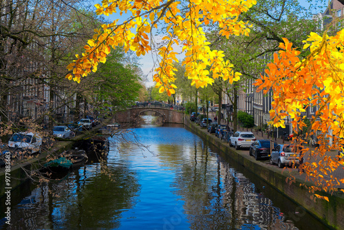 Facades of old historic Houses, bridges and trees over canal water, Amsterdam, Netherlands