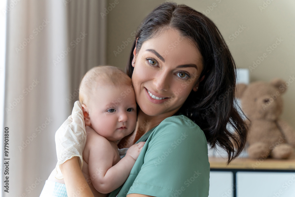 Beautiful nurse medical worker in gloves holding newborn baby in hands Beautiful nurse medical worker in gloves holding newborn baby in hands