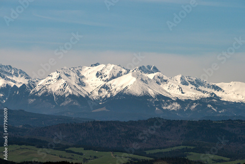 Fototapeta Naklejka Na Ścianę i Meble -  Ośnieżone szczyty górskie - góry Tatry. Widok z wieży widokowej na szczycie góry Koziarz w Beskidzkie Sądeckim. Panorama Tatr - zbliżenie
