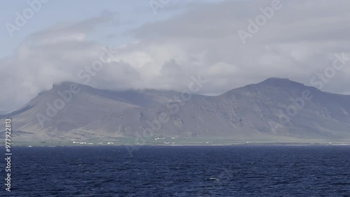 Hvalfjarðarsveit, Iceland - stunning landscape shoreline view of mountain and hiking area Akrafjall while cruising out of Reykjavik on a sunny day photo