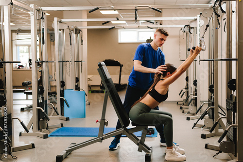 Doing therapeutic gymnastics to return lost mobility. Spine rehabilitation with kinesiotherapy. Doctor helps his patient to relax tense back muscles and reduce pain with special exercise. photo