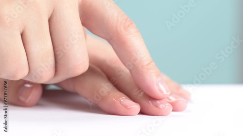 Moisturizing serum or oil for cuticles. The woman cares for hands and nails, close up. Woman applying oil from droper to nails, macro. Healthy nails concept. Hands massage with oil