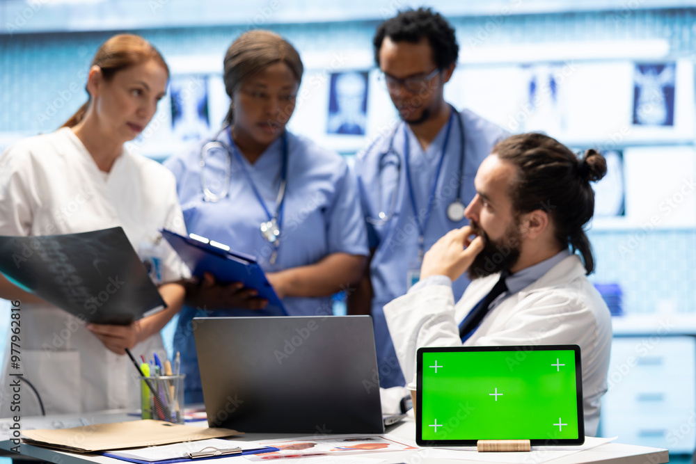 Diverse team of specialists examining radiography test scans with isolated screen in a meeting, reviewing x ray results at a treatment center. Professional staff ensuring disease prevention. Diverse team of specialists examining radiography test scans with isolated screen in a meeting, reviewing x ray results at a treatment center. Professional staff ensuring disease prevention.