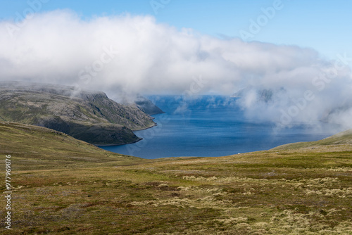 Low clouds above mossy mountains and ocean in Norway ner North cape