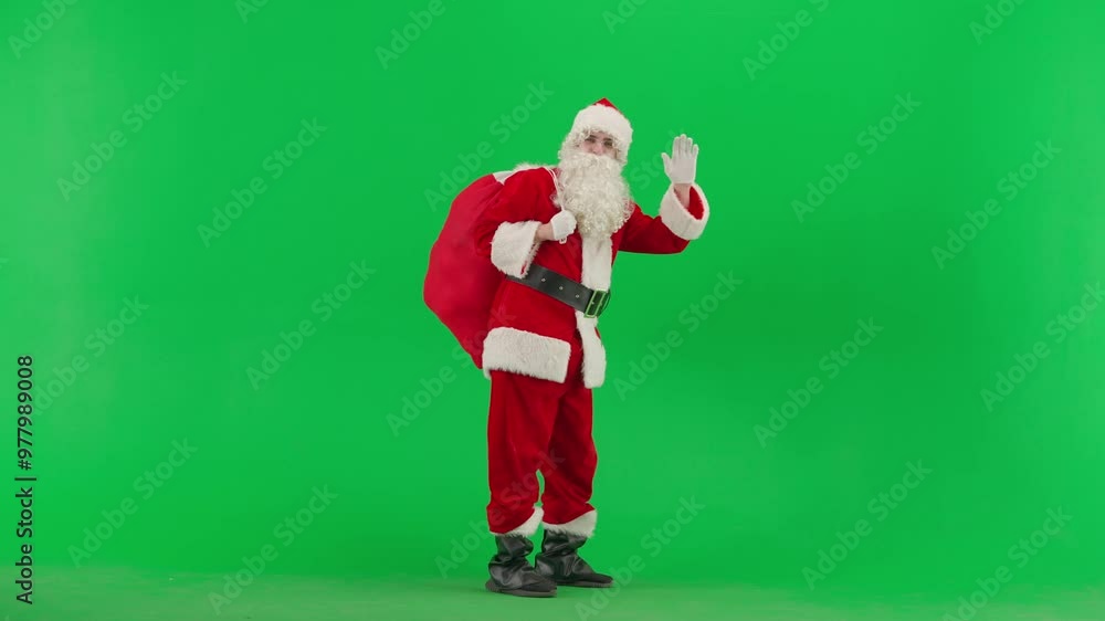 Portrait of man dressed as Santa on chroma key green screen background. Santa Claus in red outfit walks carries bag of gifts and waving hand. Portrait of man dressed as Santa on chroma key green screen background. Santa Claus in red outfit walks carries bag of gifts and waving hand.