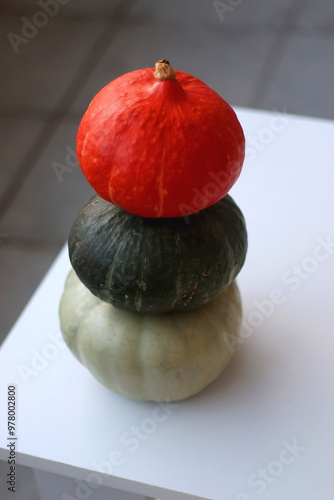 Pile of three different pumpkins on the table. Cute autumnal decoration. Selective focus. photo