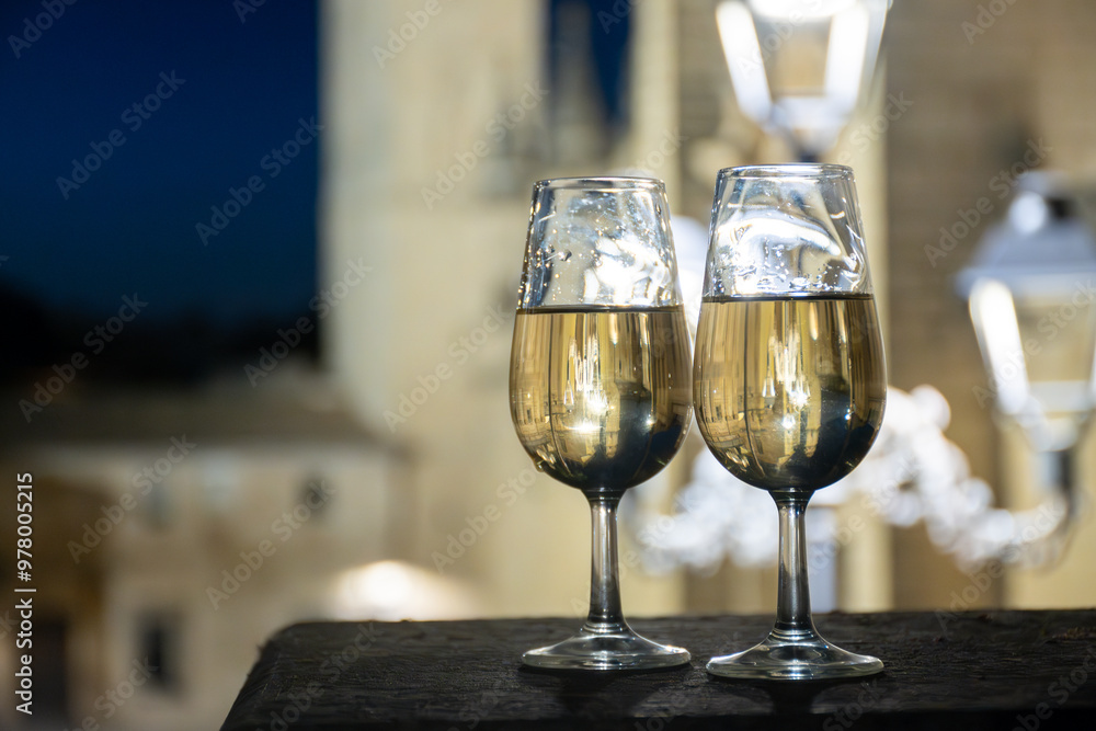 Sherry wine glasses with fino and old church on background at night in Jerez de la Frontera, wine glasses outdoor, cityview, Andalusia, Spain Sherry wine glasses with fino and old church on background at night in Jerez de la Frontera, wine glasses outdoor, cityview, Andalusia, Spain