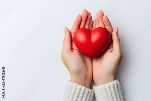 Hands Holding a Red Heart on White Background photo