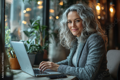 Smiling Woman Working on Laptop in Cafe