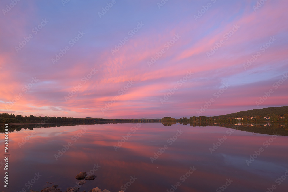 Naklejka premium Vibrant Sunset Over Calm Waters in Rovaniemi