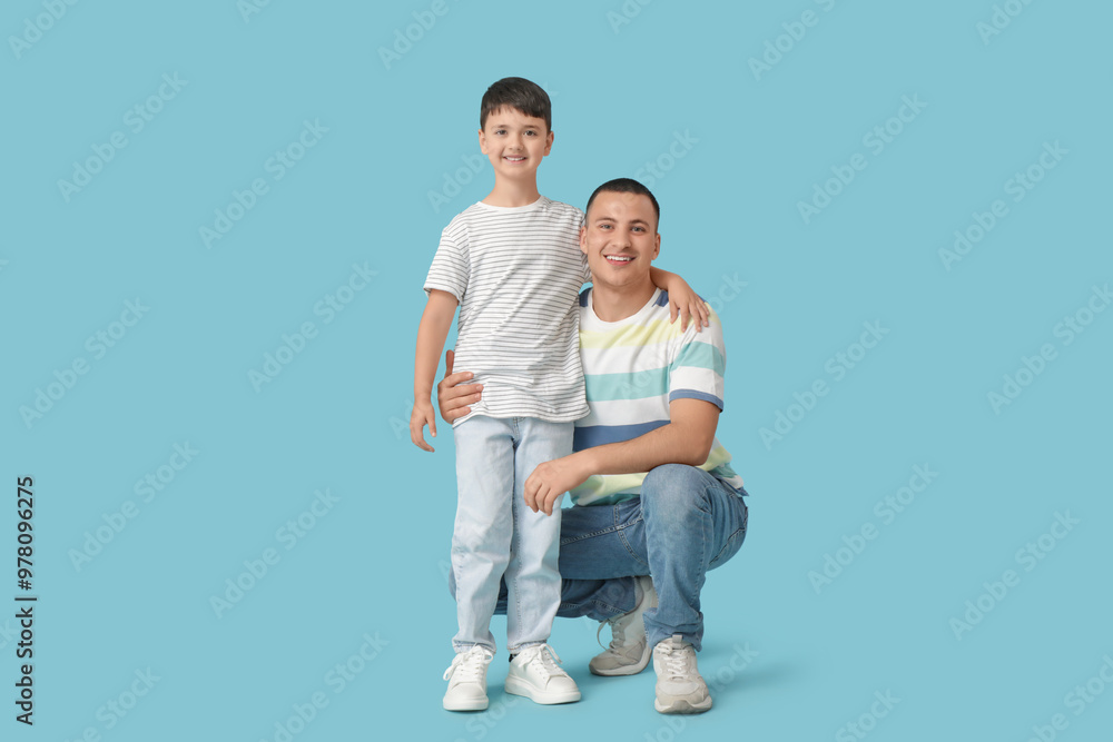 Cute little boy with his father on blue background Cute little boy with his father on blue background