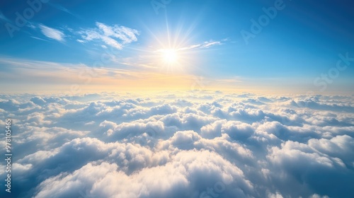 Stunning view above thick clouds from an airplane, with a clear blue sky and the sun's rays gently illuminating the cloud tops