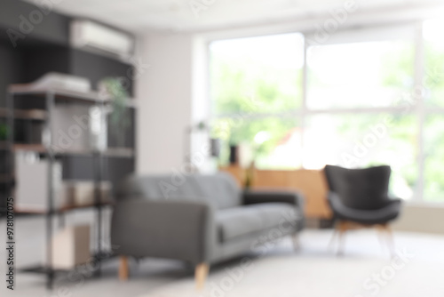 Blurred view of living room with black sofa and armchair