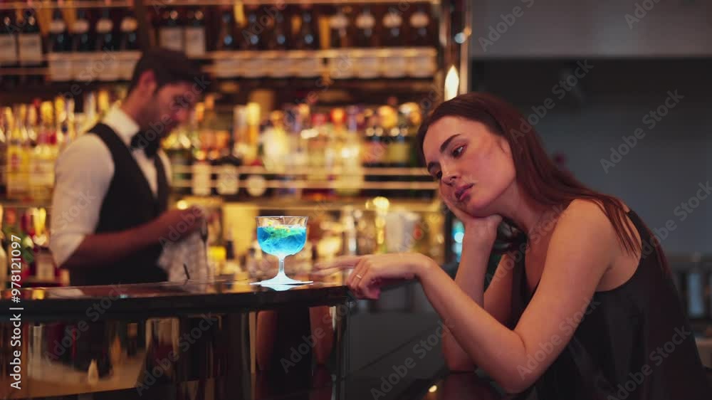 Sitting beautiful woman guest feeling bored waiting friends or couple with drinking mixed vodka in blue hawaii cocktail at luxurious counter bar for Friday meeting on bartender background. Vinosity. Sitting beautiful woman guest feeling bored waiting friends or couple with drinking mixed vodka in blue hawaii cocktail at luxurious counter bar for Friday meeting on bartender background. Vinosity.