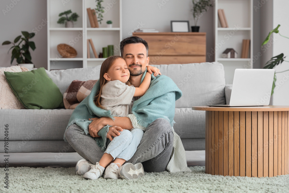 Little girl and her father with warm plaid hugging on carpet at home Little girl and her father with warm plaid hugging on carpet at home