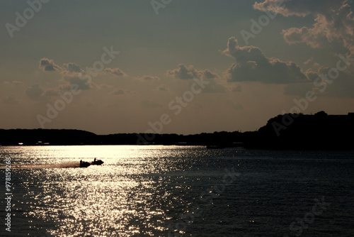 Personal watercraft through the sunset on the lake photo