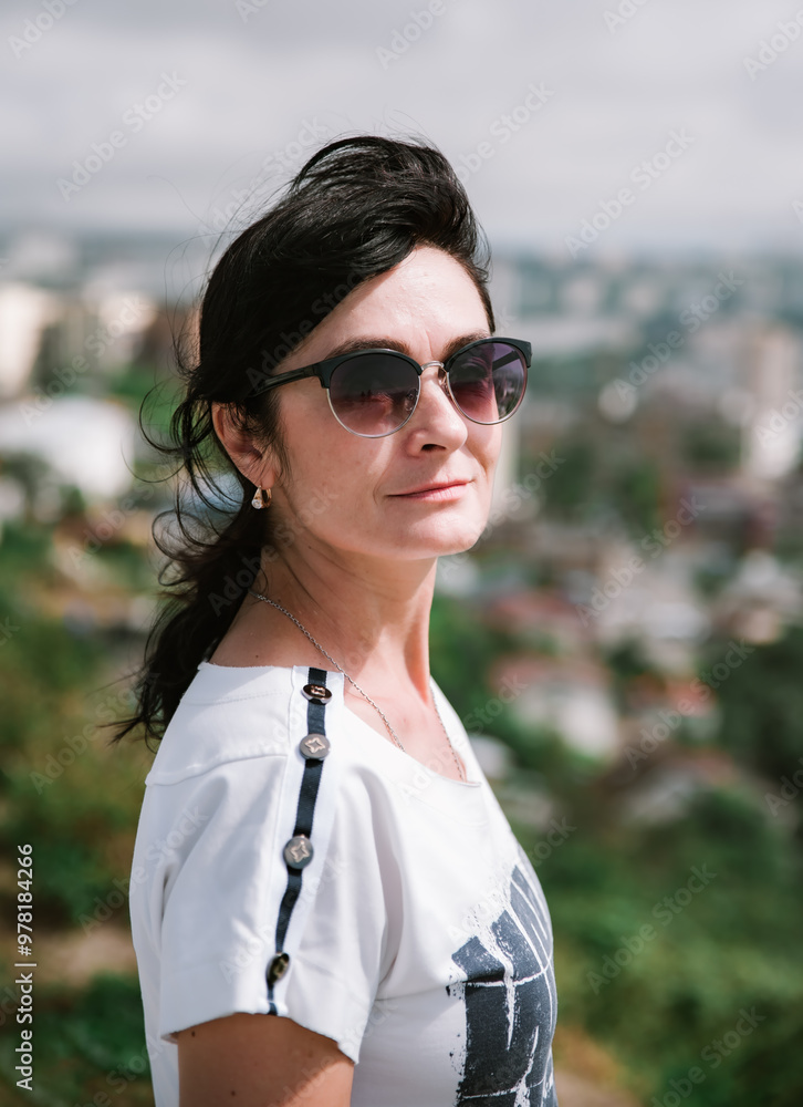 50 years old Russian brunette woman in sunglasses standing against vladivostok city view, portrait 50 years old Russian brunette woman in sunglasses standing against vladivostok city view, portrait