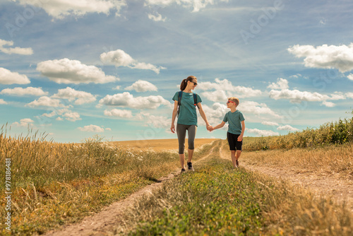 Mother and child holding hands walking in the countryside, Mom and son bonding 