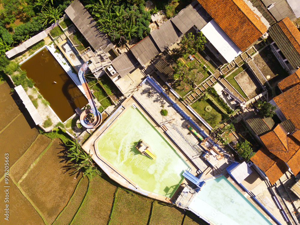 Abandoned swimming pool view from an aerial perspective. A swimming pool that has been abandoned for a long time because it was deserted by visitors. Abandoned place photography concept Abandoned swimming pool view from an aerial perspective. A swimming pool that has been abandoned for a long time because it was deserted by visitors. Abandoned place photography concept