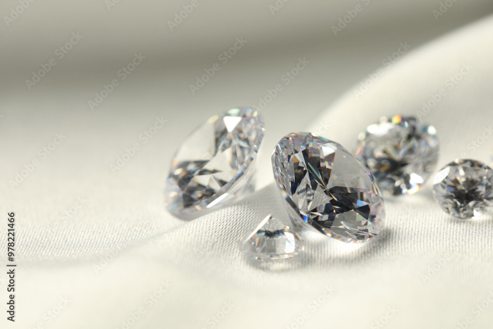 Many beautiful shiny diamonds on white fabric, closeup. Space for text Many beautiful shiny diamonds on white fabric, closeup. Space for text