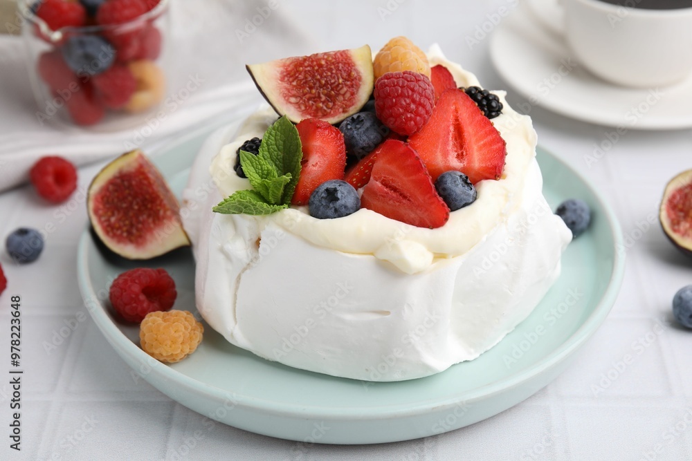 Pavlova cake (meringue dessert) with whipped cream, fresh berries, mint and fig on white table, closeup Pavlova cake (meringue dessert) with whipped cream, fresh berries, mint and fig on white table, closeup