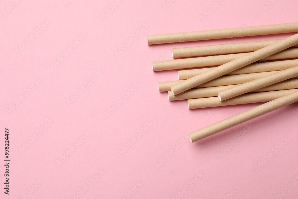 Bamboo drinking straws on pink background, top view. Space for text Bamboo drinking straws on pink background, top view. Space for text