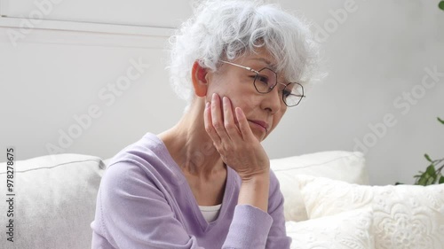 悩むシニア女性　リビングルーム