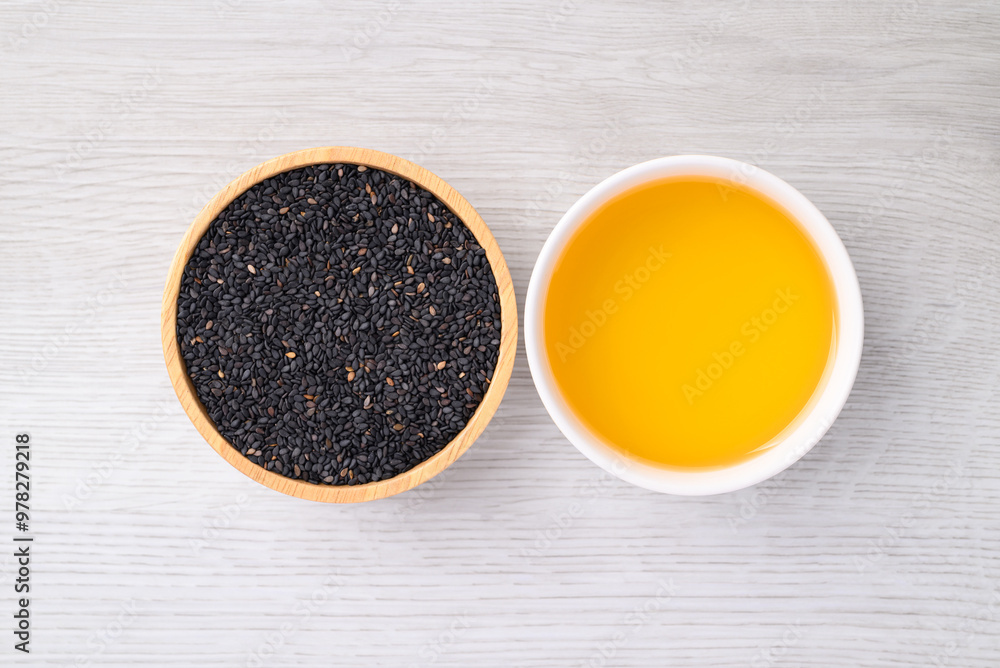 Black sesame seeds and oil (Cold pressed) in bowl on white table, Food ingredient, Top view Black sesame seeds and oil (Cold pressed) in bowl on white table, Food ingredient, Top view