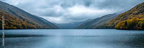 Serene lake reflecting autumn colors and overcast sky photo