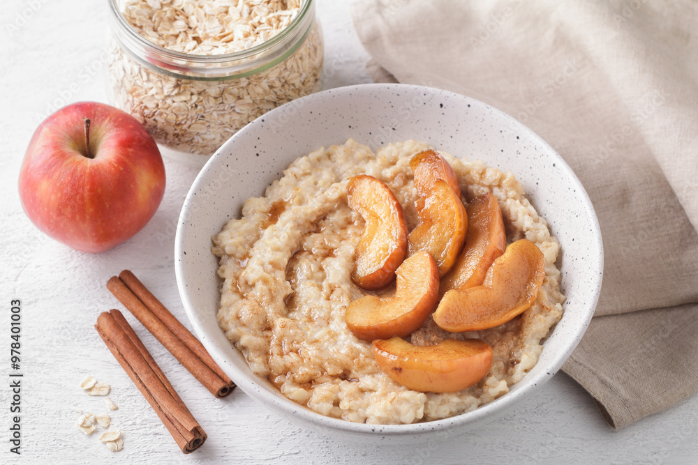 Sweet oatmeal porridge with baked apple slices, cinnamon and caramel sauce Sweet oatmeal porridge with baked apple slices, cinnamon and caramel sauce