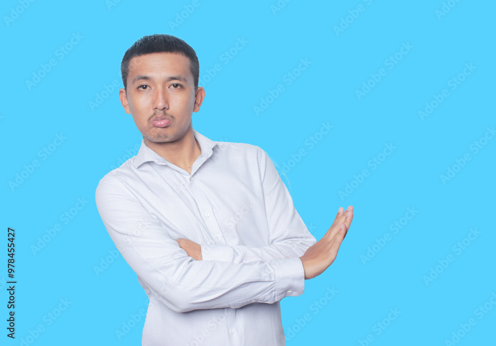 Concerned Indonesian Asian Man showing refusal sign, saying no, raise awarness, standing on the blue background. Concerned Indonesian Asian Man showing refusal sign, saying no, raise awarness, standing on the blue background.