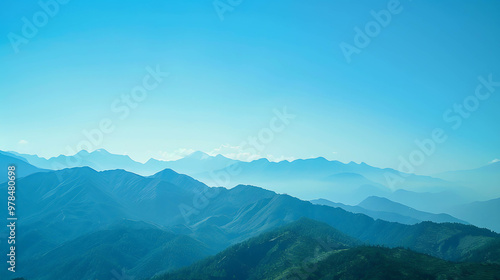 A panoramic view of a mountain range with a clear blue sky overhead.